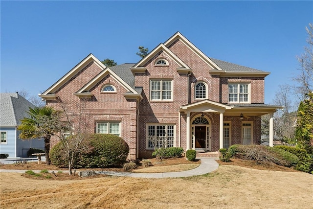 view of front of home with brick siding and a front yard