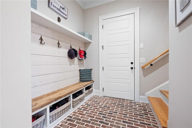 mudroom with brick floor and baseboards