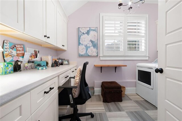 office space with a notable chandelier, built in desk, baseboards, washer / dryer, and vaulted ceiling