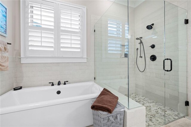 bathroom with a stall shower, a wealth of natural light, and a freestanding bath