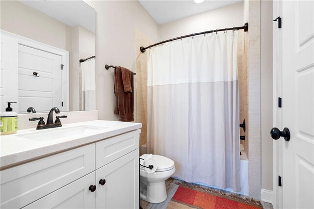 full bath featuring vanity, toilet, and shower / tub combo