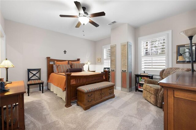 bedroom with light carpet, visible vents, and baseboards