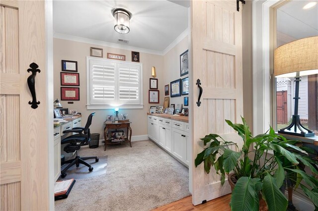 office area featuring visible vents, light carpet, baseboards, and ornamental molding