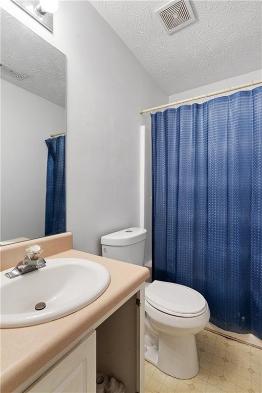 full bath with visible vents, toilet, vanity, a textured ceiling, and tile patterned floors