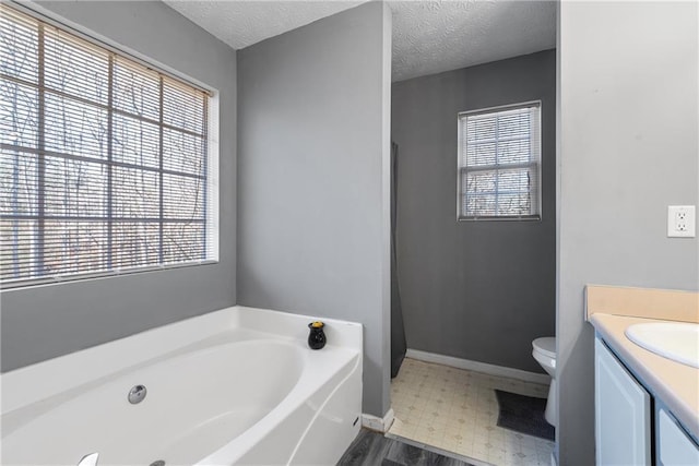 full bath featuring tile patterned floors, a healthy amount of sunlight, vanity, a textured ceiling, and a bath