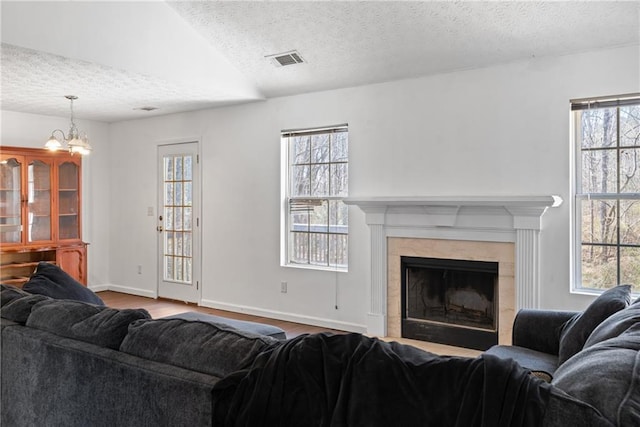 living area with a textured ceiling, plenty of natural light, and a fireplace with flush hearth