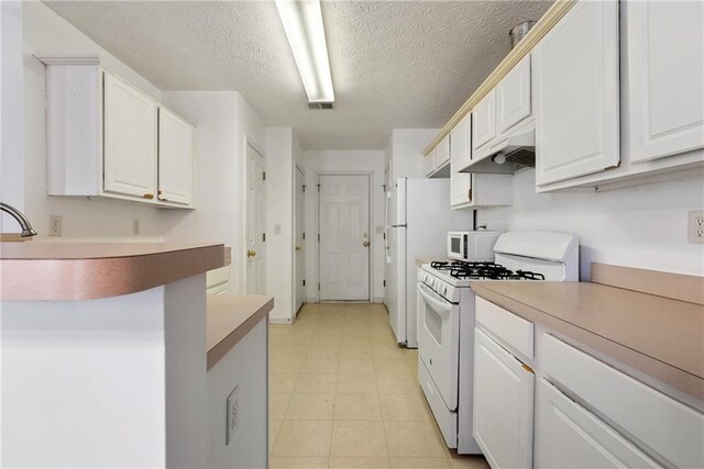 kitchen featuring visible vents, white cabinetry, a textured ceiling, white appliances, and under cabinet range hood