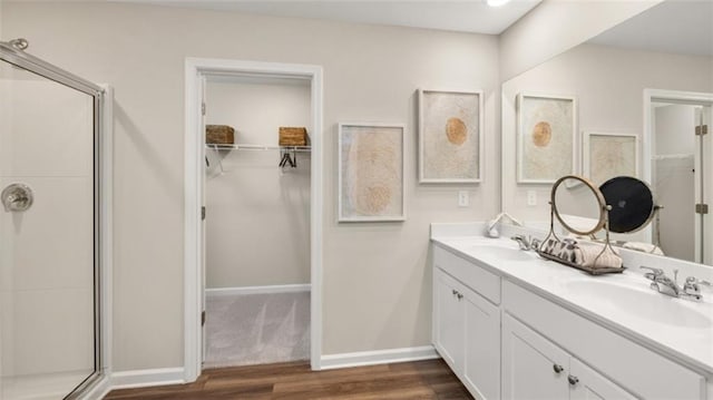 bathroom featuring vanity, a shower with shower door, and wood-type flooring