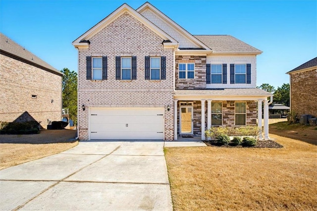 view of front facade with brick siding, a front yard, a garage, stone siding, and driveway