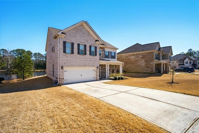 traditional home featuring a garage, a front yard, concrete driveway, and brick siding