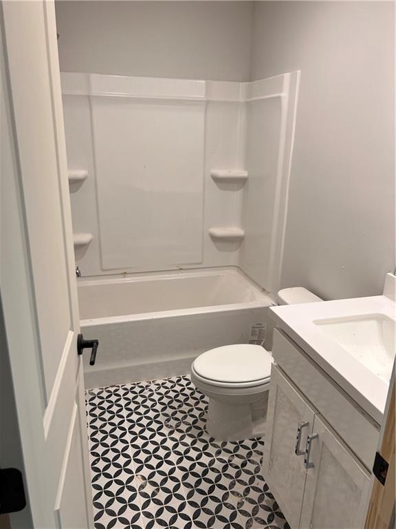 full bathroom with toilet, tile patterned floors, shower / tub combination, and vanity