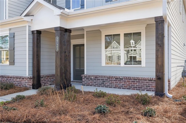 view of exterior entry featuring covered porch