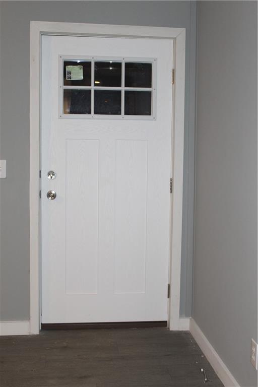 interior space featuring dark wood-style floors, beam ceiling, baseboards, and a ceiling fan