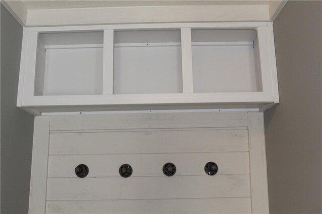 kitchen featuring white cabinetry, beamed ceiling, a textured ceiling, and baseboards