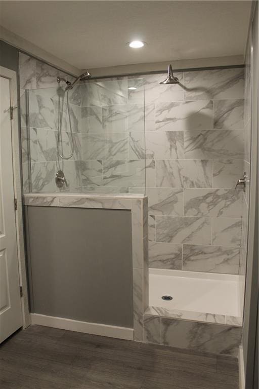 bathroom featuring a tile shower and hardwood / wood-style flooring