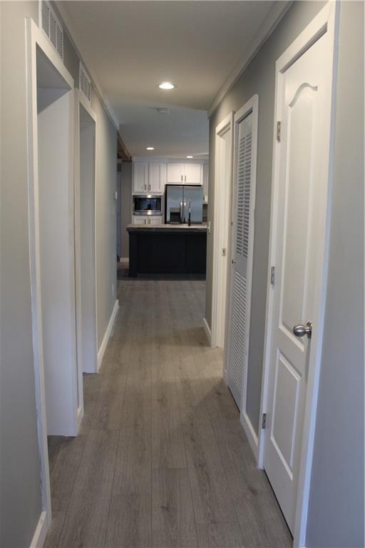 bathroom featuring double vanity, wood finished floors, and a sink