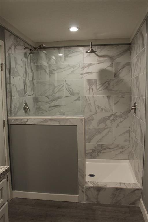 bathroom featuring vanity, hardwood / wood-style flooring, and a tile shower