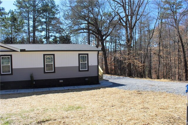 view of side of property with crawl space, cooling unit, and a lawn