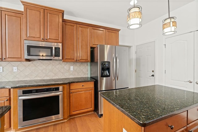 kitchen with decorative backsplash, stainless steel appliances, and a center island