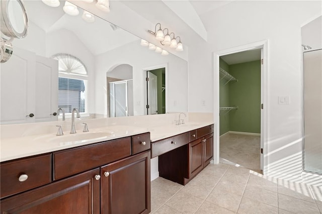 bathroom featuring lofted ceiling, vanity, tile patterned flooring, and a shower with shower door