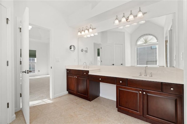 bathroom with tile patterned flooring, vanity, and lofted ceiling