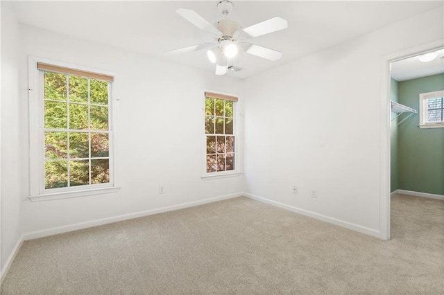 empty room with ceiling fan and light carpet