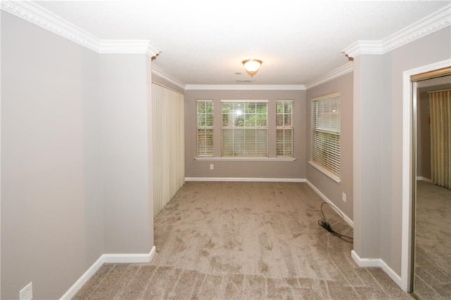 carpeted spare room with ornamental molding and baseboards