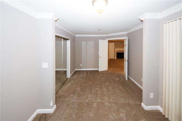 carpeted empty room featuring baseboards and crown molding