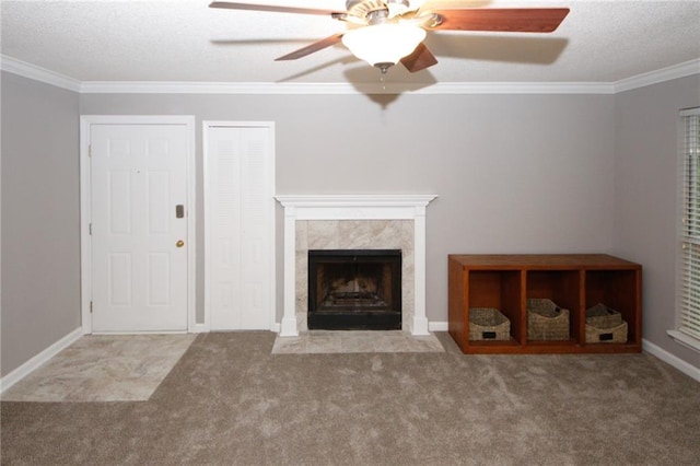 unfurnished living room with a textured ceiling, baseboards, a tiled fireplace, carpet, and crown molding