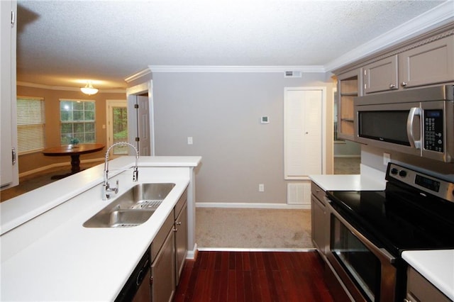 kitchen featuring stainless steel appliances, light countertops, visible vents, ornamental molding, and a sink