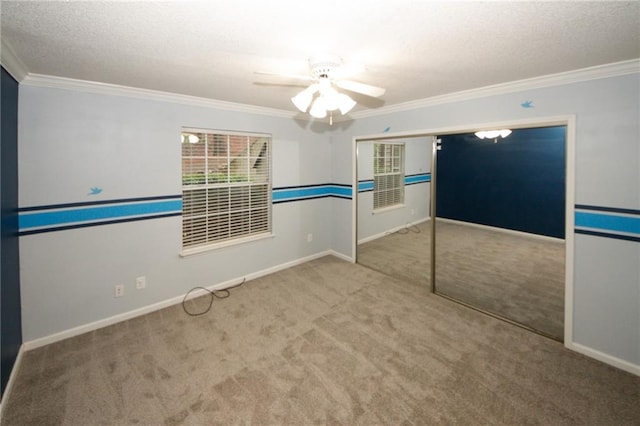 carpeted empty room with crown molding and a textured ceiling