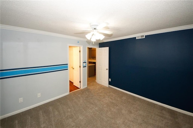 unfurnished bedroom with baseboards, visible vents, a textured ceiling, crown molding, and carpet flooring