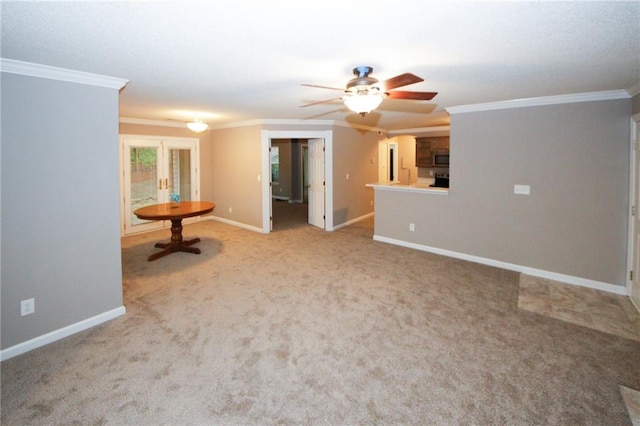 carpeted empty room with ornamental molding, baseboards, and a ceiling fan