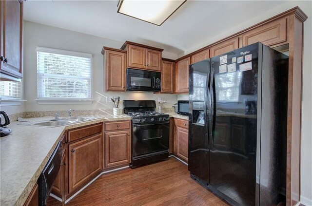 kitchen featuring black appliances, sink, and dark hardwood / wood-style floors