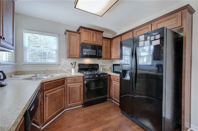 kitchen featuring sink, dark hardwood / wood-style flooring, and black appliances