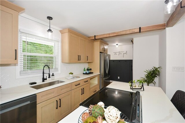 kitchen with light brown cabinets, sink, stainless steel appliances, and hanging light fixtures