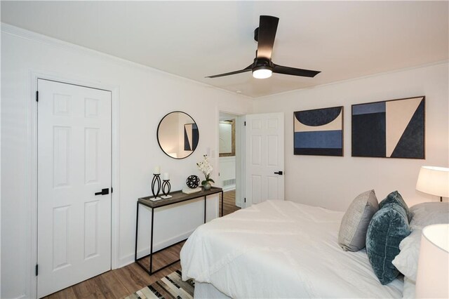 bedroom with hardwood / wood-style flooring, ceiling fan, and ornamental molding