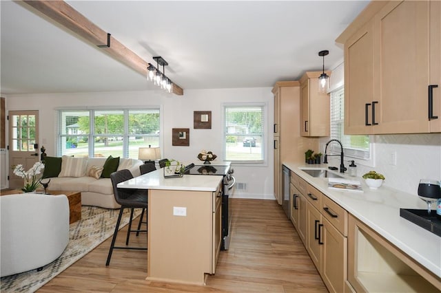 kitchen featuring a center island, sink, hanging light fixtures, a kitchen bar, and stainless steel appliances