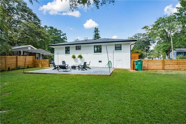 rear view of property featuring a lawn and a patio area