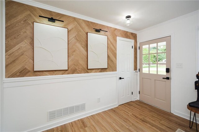 entryway featuring hardwood / wood-style flooring and crown molding