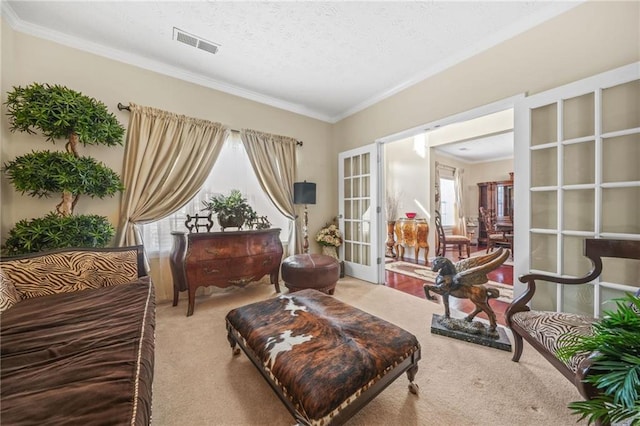 sitting room with visible vents, crown molding, carpet flooring, french doors, and a textured ceiling