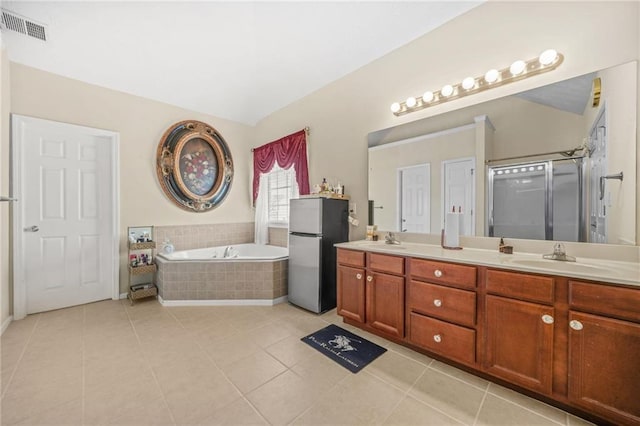 full bath with a garden tub, double vanity, visible vents, and a sink