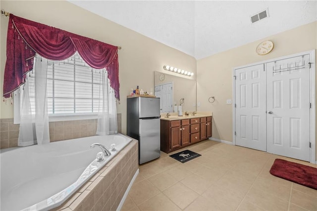 bathroom with tile patterned floors, visible vents, a bath, and vanity