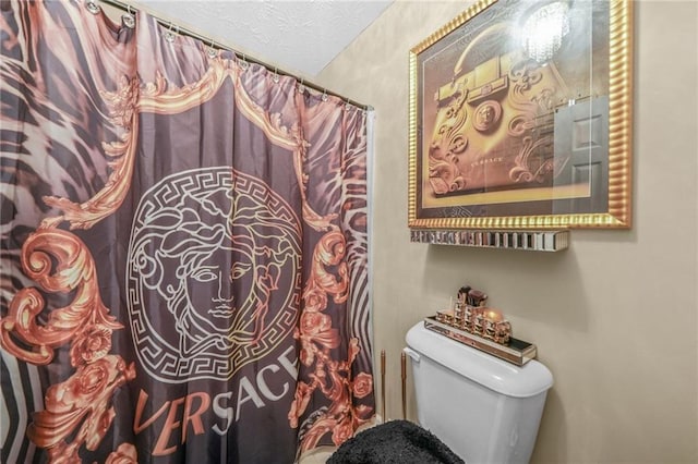 bathroom with toilet and a textured ceiling