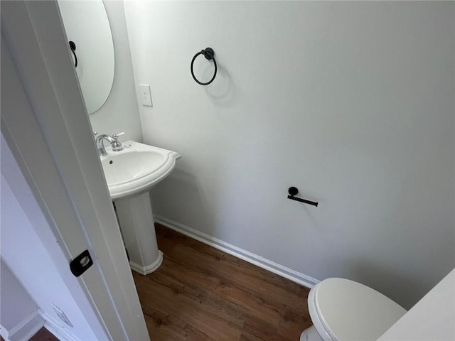 bathroom with hardwood / wood-style floors, toilet, and sink