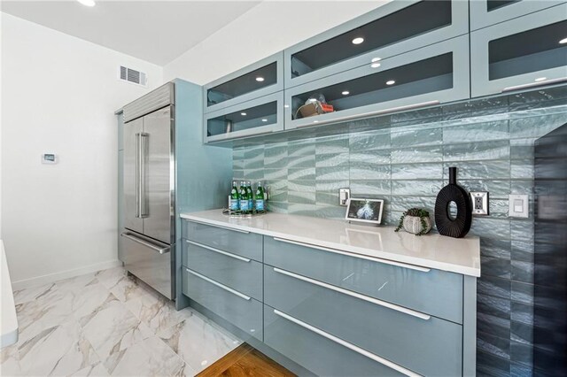 kitchen featuring ceiling fan, backsplash, ventilation hood, light hardwood / wood-style floors, and stainless steel built in fridge