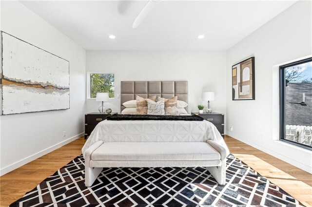 bedroom featuring wood-type flooring, a barn door, access to outside, and ceiling fan