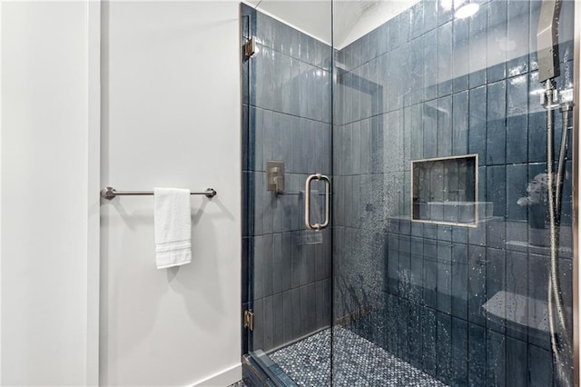 full bath with a stall shower and baseboards