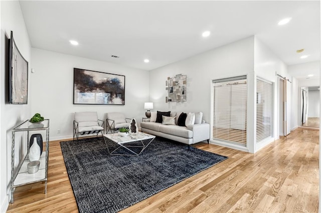 living area with light wood-style floors, baseboards, and recessed lighting
