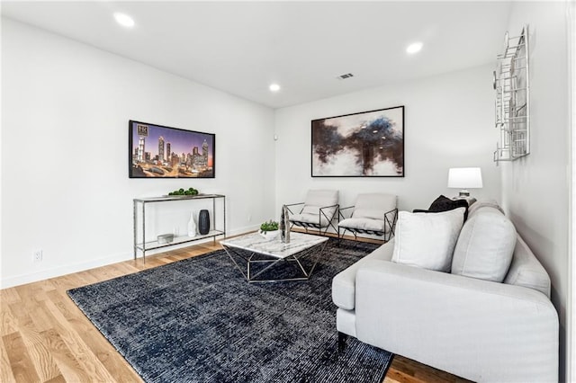 living area with wood finished floors, baseboards, and recessed lighting
